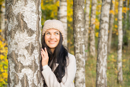 Beautiful young girl in the autumn forest on a sunny dayの写真素材