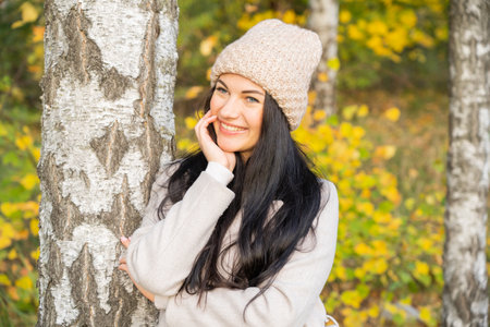 Beautiful young girl in the autumn forest on a sunny dayの写真素材