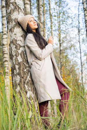 Beautiful young girl in the autumn forest on a sunny dayの写真素材