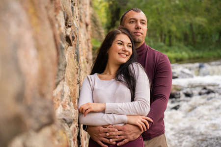 beautiful young couple posing near the riverの写真素材