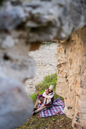 a guy and a girl are drinking tea near the riverの写真素材