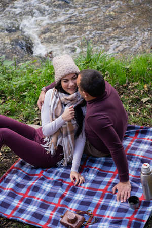 a guy and a girl are drinking tea near the riverの写真素材