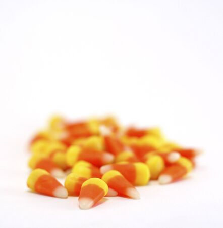 Orange, yellow and white candy corns isolated on white.の写真素材