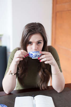 Young woman is drinking a cup of tea
