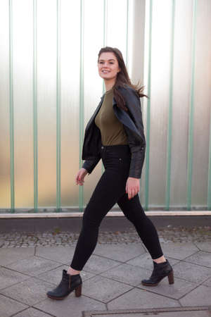 Young woman walking on a sidewalkの写真素材