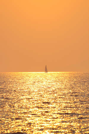 Sailing boat in sea at sunsetの写真素材