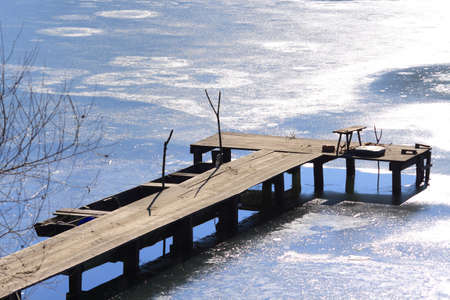 Old wooden dock on frozen lakeの写真素材