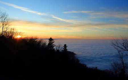 Winter sunset sky from mountain with fog  down in lowloandの写真素材
