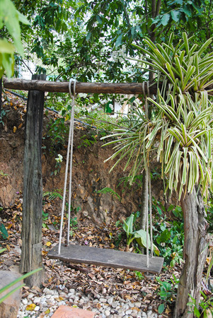 Old wood swing bench in the parkの写真素材