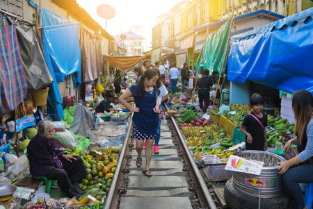MAEKLONG, THAILAND-DECEMBER 11,2016 : The famous railway market or folding umbrella market at Maeklong, Thailand, A famous market in Thailand and sixth times a day the train runs through these stalls.のeditorial素材