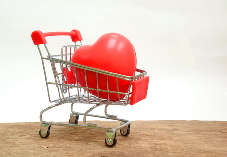 Red heart in a shopping cart on wood background romance or valentine's gift concept.の写真素材