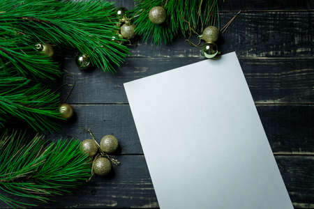 Christmas holiday background - decoration on a dark wooden table with blank white sheet. New year...