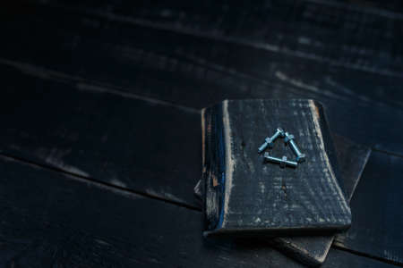 Some bolts and nuts on black wooden background. Professional instruments, garage equipment, metal tools. Place for text.の写真素材
