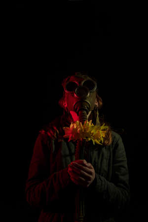 Girl in gas mask with flowers in hands. Enviromental pollution, nature protection, ecology disaster...