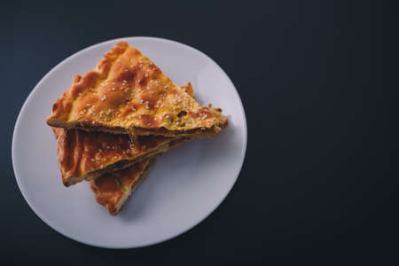Some pieces of meat and carrot pie on white plate on black wooden background. Tasty healthy food. Diet, nutrition, eating habits concept. Place for text.の写真素材