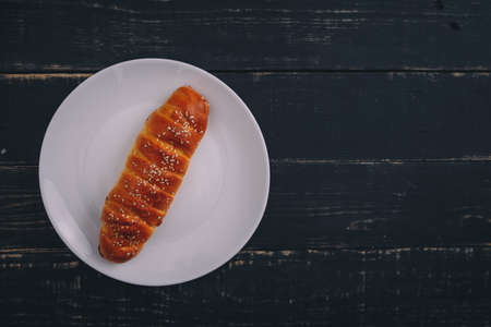 Roll-up apple pie on white plate on black wooden background. Tasty healthy food. Diet, nutrition, eating habits concept. Place for text.の写真素材