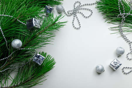 Christmas holiday background - decoration on a white table background. New year pine and silver...