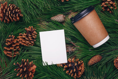 Green pine tree branches, cones background, paper cup of coffee mock up, top view. Merry Christmas beverage, hot drink for winter walk, social distancing, self-care, covid-19 conceptの写真素材