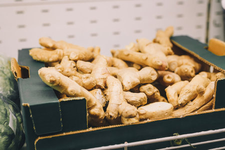 Ginger roots in box on supermarket shelf, grocery department. Food, vegetables, hot spices for bakery and beveragesの写真素材