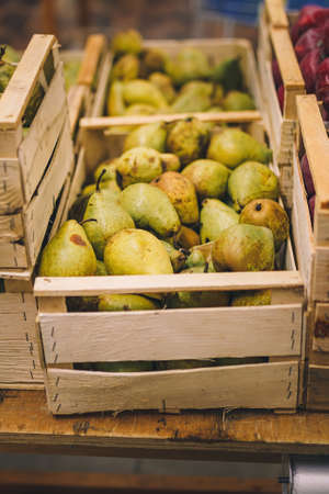 sweet ripe pears in wooden box. Seasonal fruit department in supermarket, food store. Shop local, farm products, vegan, vegetarian foodの写真素材