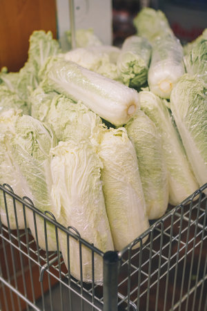 Fresh natural chinese cabbage in trolley, shop basket, vegetables in grocery department of...