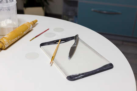 Kitchen board, brushes and dough rolling pin in some flour on white round table. Homemade pastry, bakery, cooking food conceptの写真素材