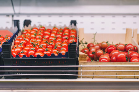 Boxes of red fresh sweet tomatoes in grocery department in shopping center, supermarket, food store. Vegan food, no animal local productsの写真素材