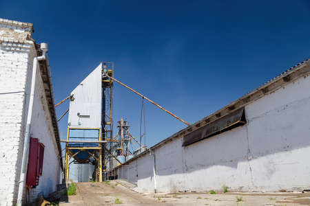 Place for loading of grain and crops in trucks from granary elevator storage before export, blue sky background.の写真素材