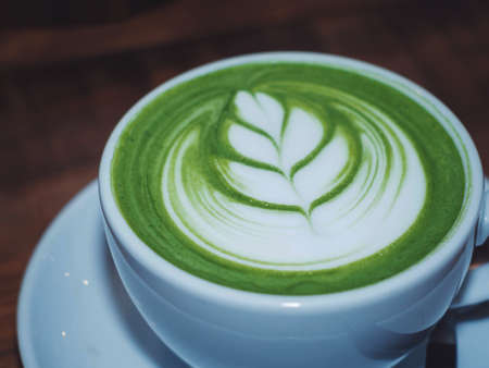 art latte hot green tea matcha on wooden table in the cafeの写真素材