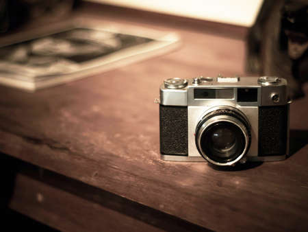 Old retro camera on vintage wooden boards abstract background.の写真素材