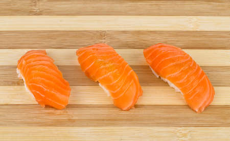 Closeup photo with salmon sushi on wooden board の写真素材