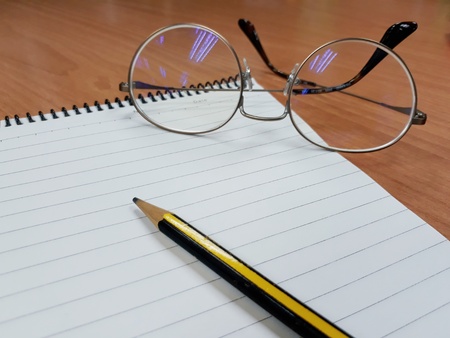 Notebook, pencil and glassesの写真素材