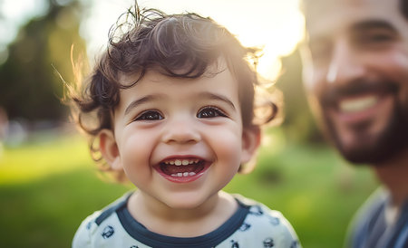 Portrait of a smiling little boy with his father in the parkの素材