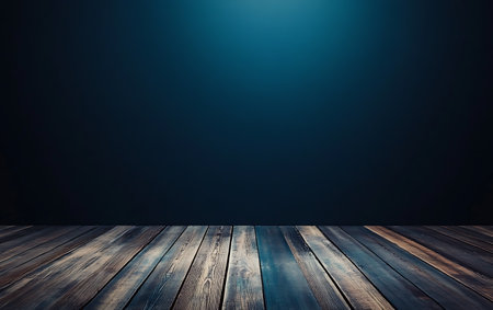 Wooden floor against a dark blue wall with a spot of lightの素材