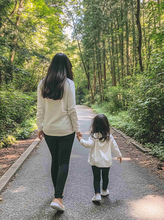 Mother and daughter walking in the forest. Concept of friendly family.の素材