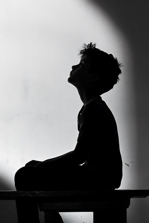 silhouette of a young boy in black and white with shadowの写真素材