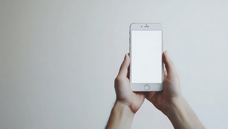 Man's hands holding a smartphone with a blank screen on a white backgroundの写真素材
