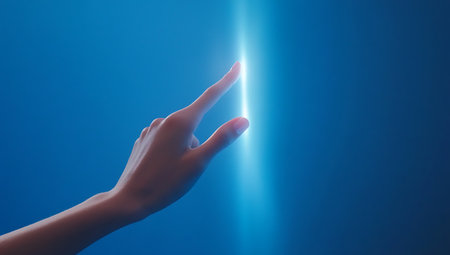 Human hand touching a light on a blue background with copy space.の写真素材