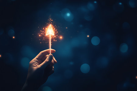 Hand holding glowing sparkler on dark blue bokeh background. Christmas and New Year conceptの写真素材