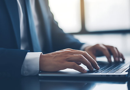 Close up of businessman hands typing on laptop computer keyboard in office.の写真素材