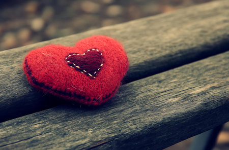 Red heart on a wooden bench. Valentines day background. Vintage tonedの写真素材