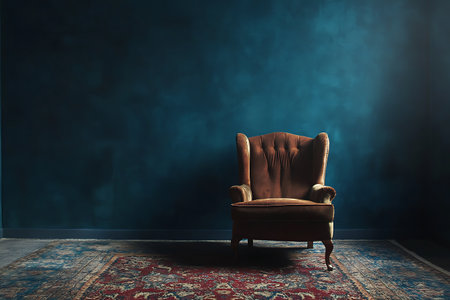 Vintage armchair in a dark room with blue wall and carpetの写真素材
