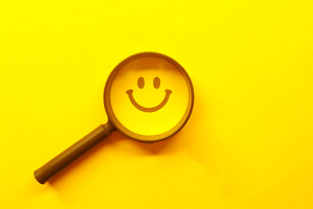 magnifying glass with smiley face on yellow background, top viewの写真素材