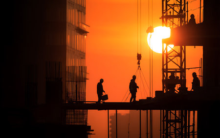 Silhouette of construction workers on the construction site at sunset.の写真素材