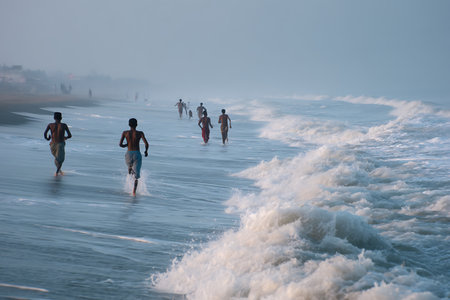 People on the beach in the misty morning at sunriseの写真素材