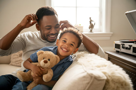 Father and son playing with teddy bear in living room at homeの写真素材