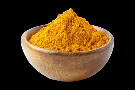 Turmeric powder in a wooden bowl isolated on black background with clipping pathの写真素材