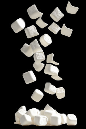 Pile of white marshmallows falling, isolated on black backgroundの写真素材