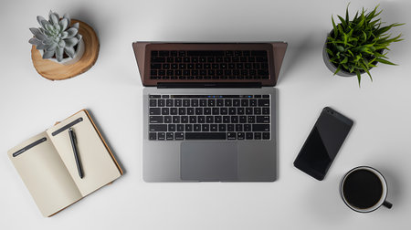 Top view of modern workplace with laptop, smartphone, notebook and coffee cup on white background.の写真素材
