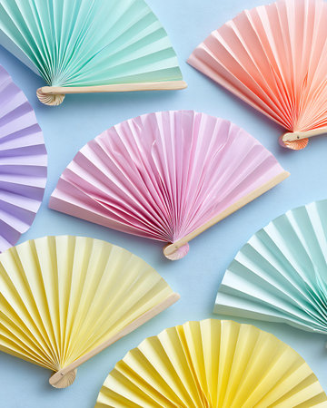 Colorful paper fan pattern on blue background. Flat lay, top viewの写真素材